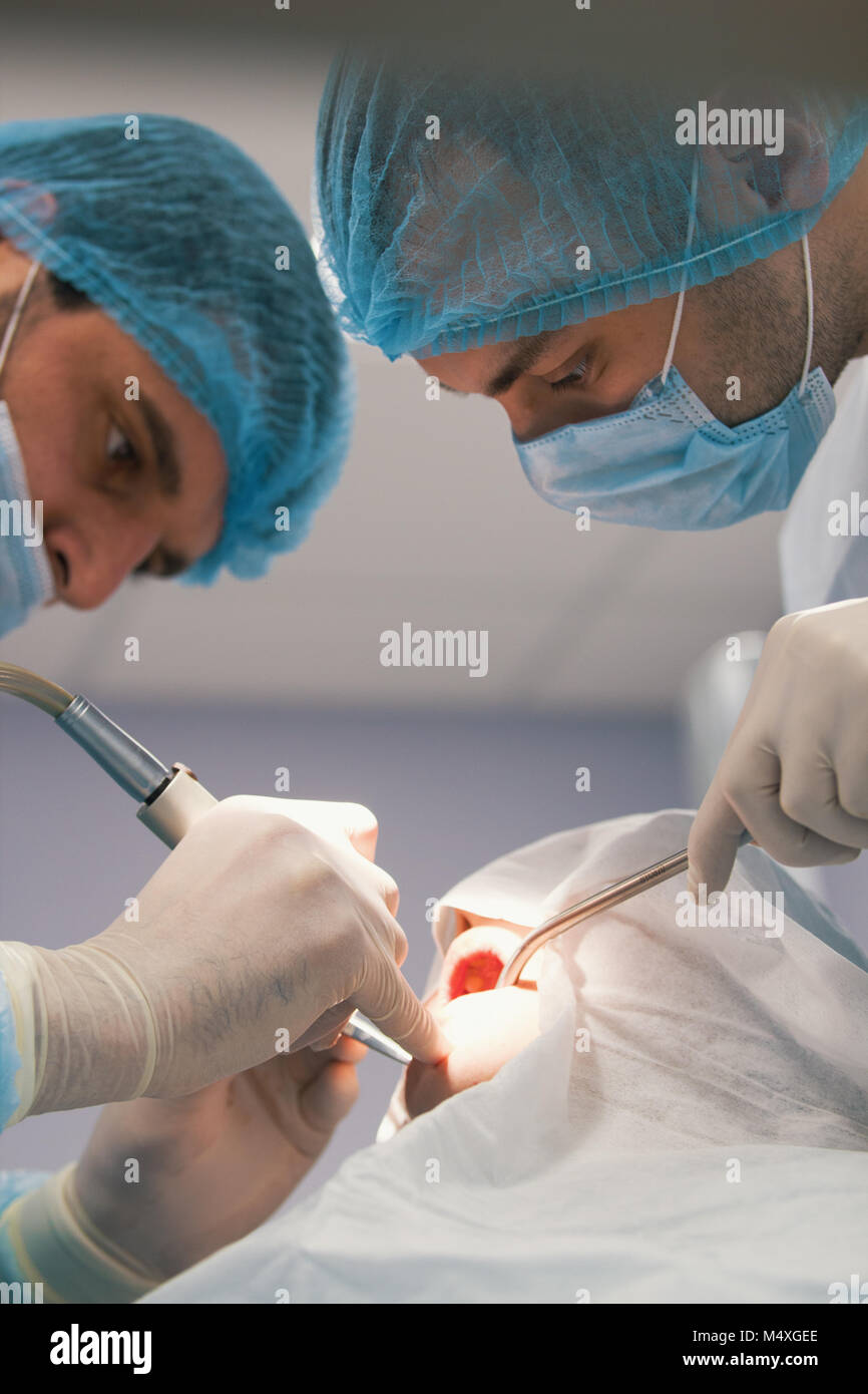 Two surgeons in blue robes make operation in surgery room Stock Photo