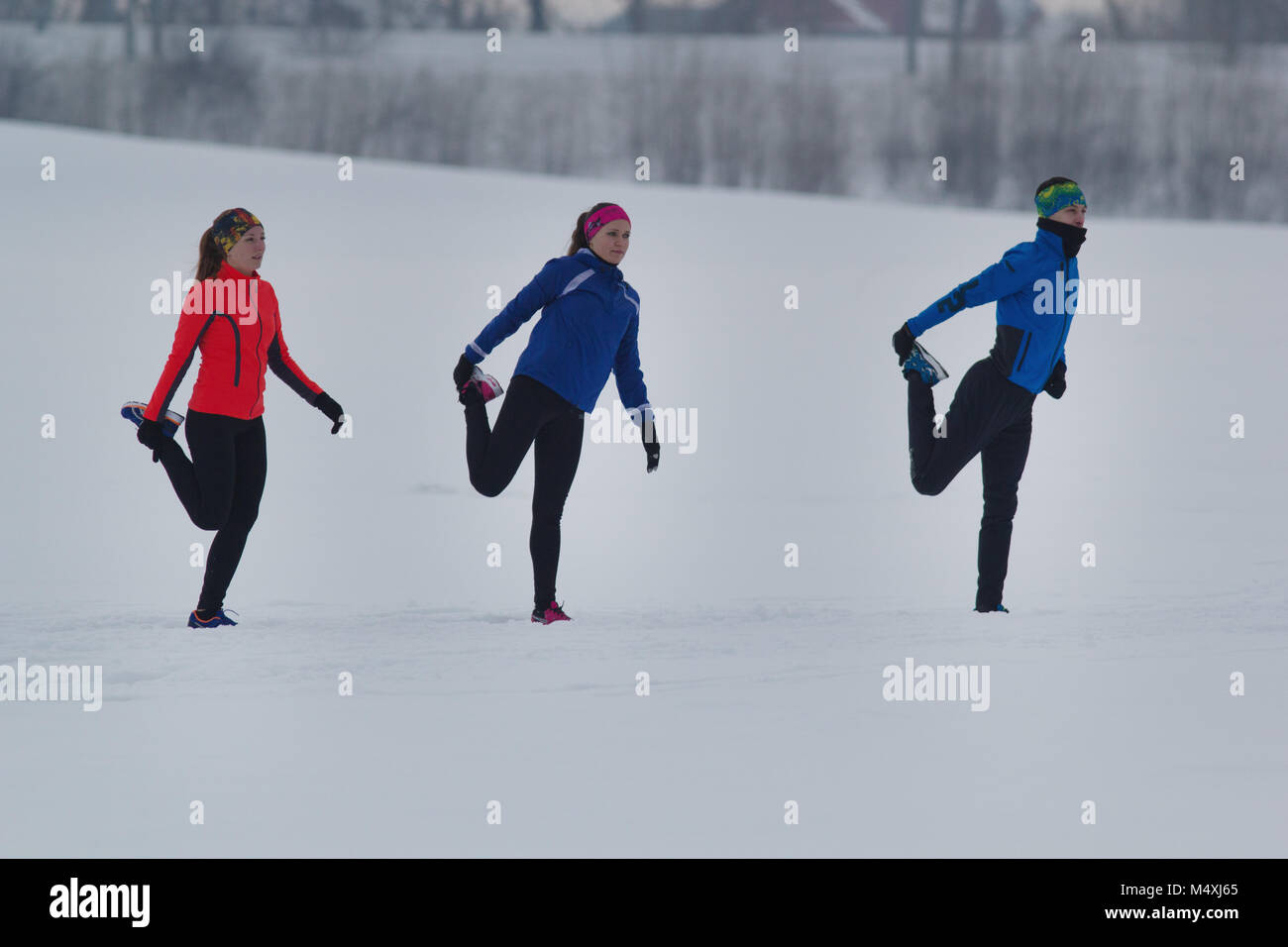 Group of athletes warming up and stretching before exercise in winter