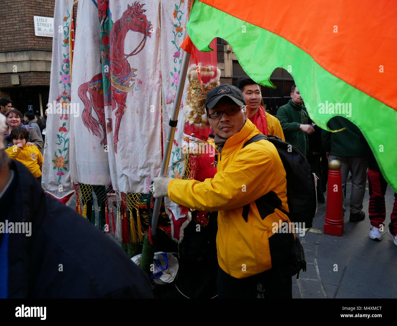 Man carrying flags during Chinese New Year in London's China town 2018. Stock Photo