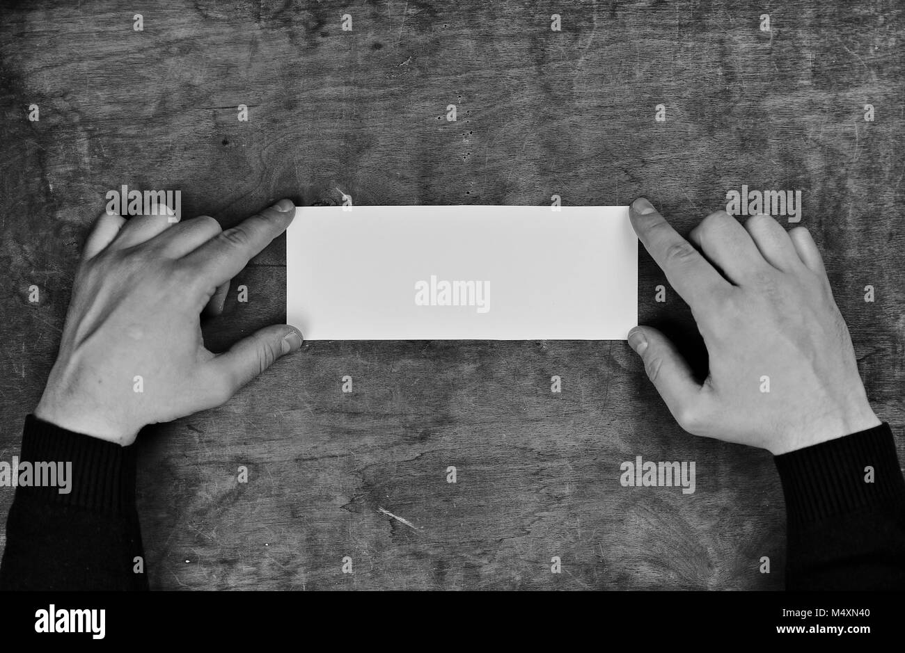 monochrome photo male hands holding a white blank sheet of paper Stock ...