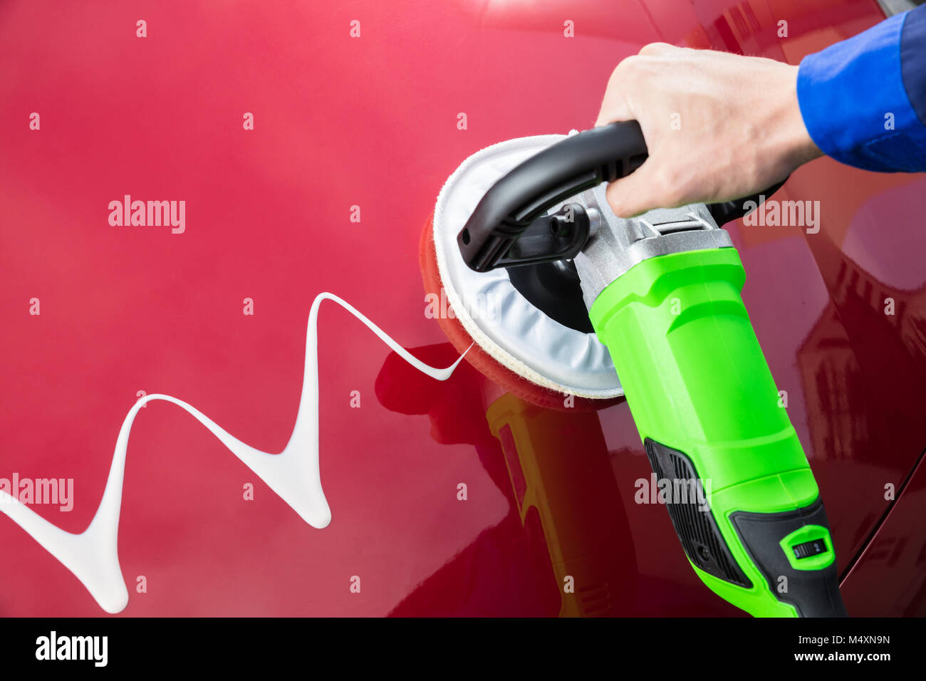 Closeup Of Person's Hand Polishing Car Hood With Orbital Polisher And