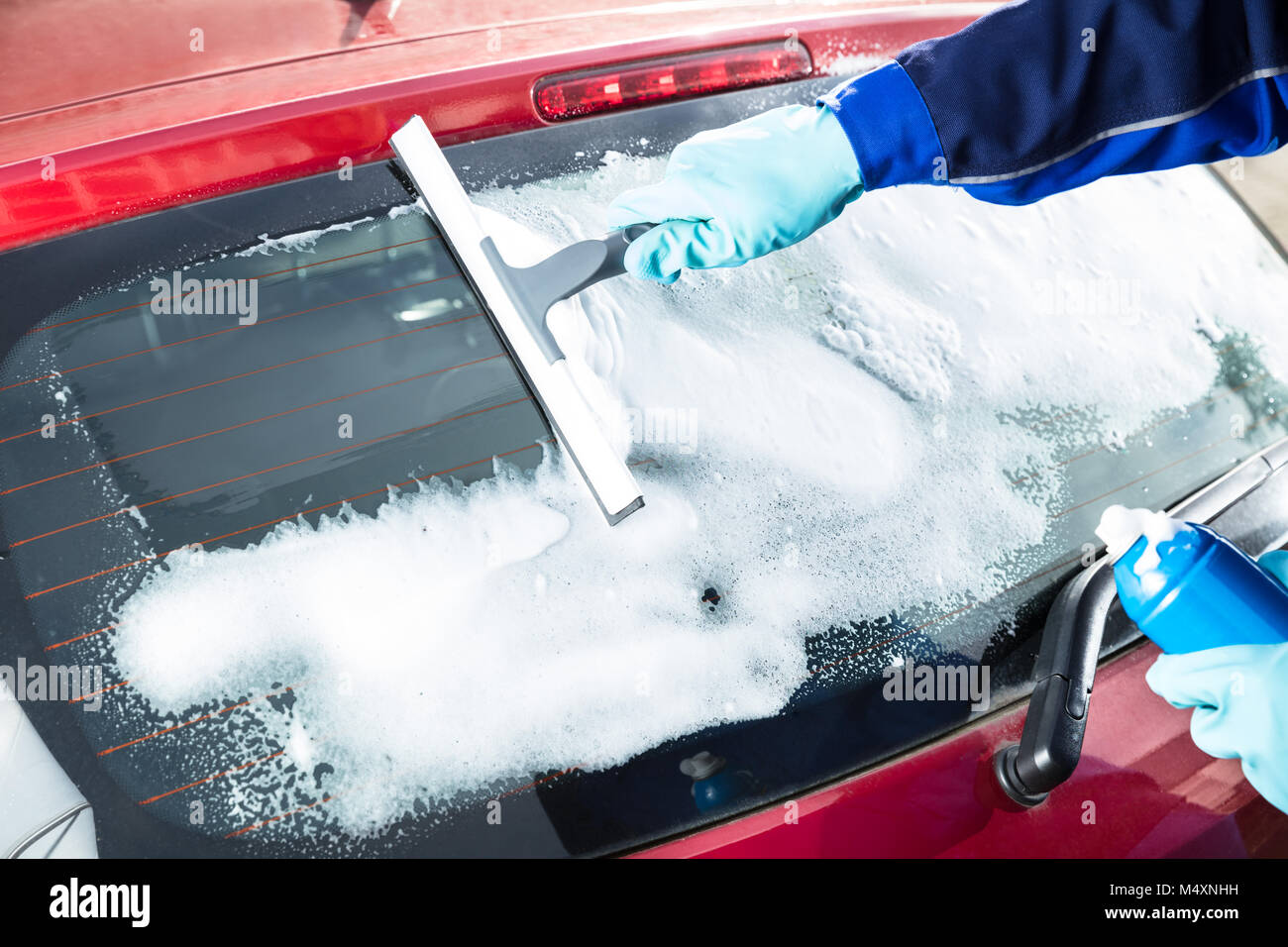 Close-up Of Man's Hand Cleaning The Car Window By Squeegee Stock