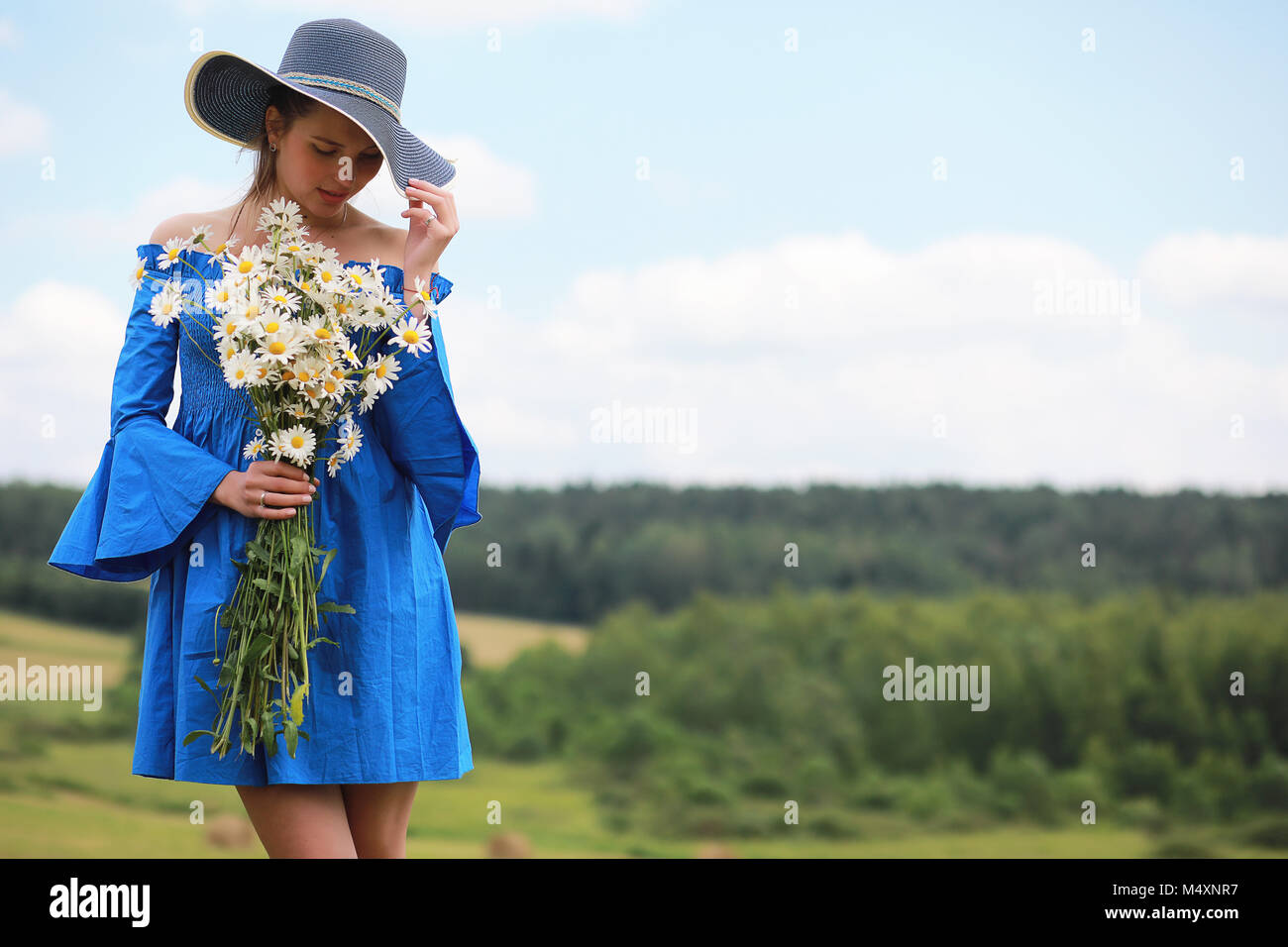Young cute girl in a hat in a field at sunset Stock Photo - Alamy