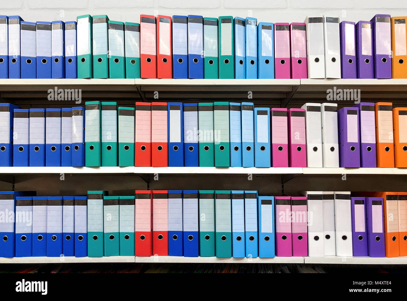 colorful ring binder folder on white shelves, office stationary Stock