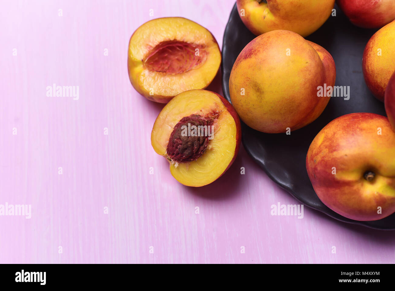 composition of ripe peaches on a pink background Stock Photo - Alamy