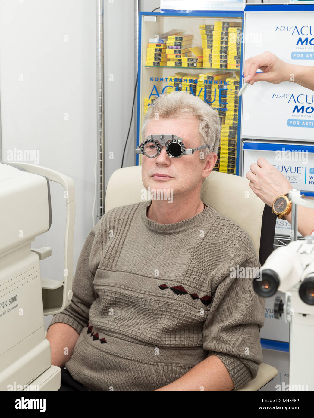 SAINT PETERSBURG, RUSSIA - FEBRUARY 13, 2018: A mature man visits an ophthalmologist. Eyesight check with trial frame. Doctor and patient with model r Stock Photo