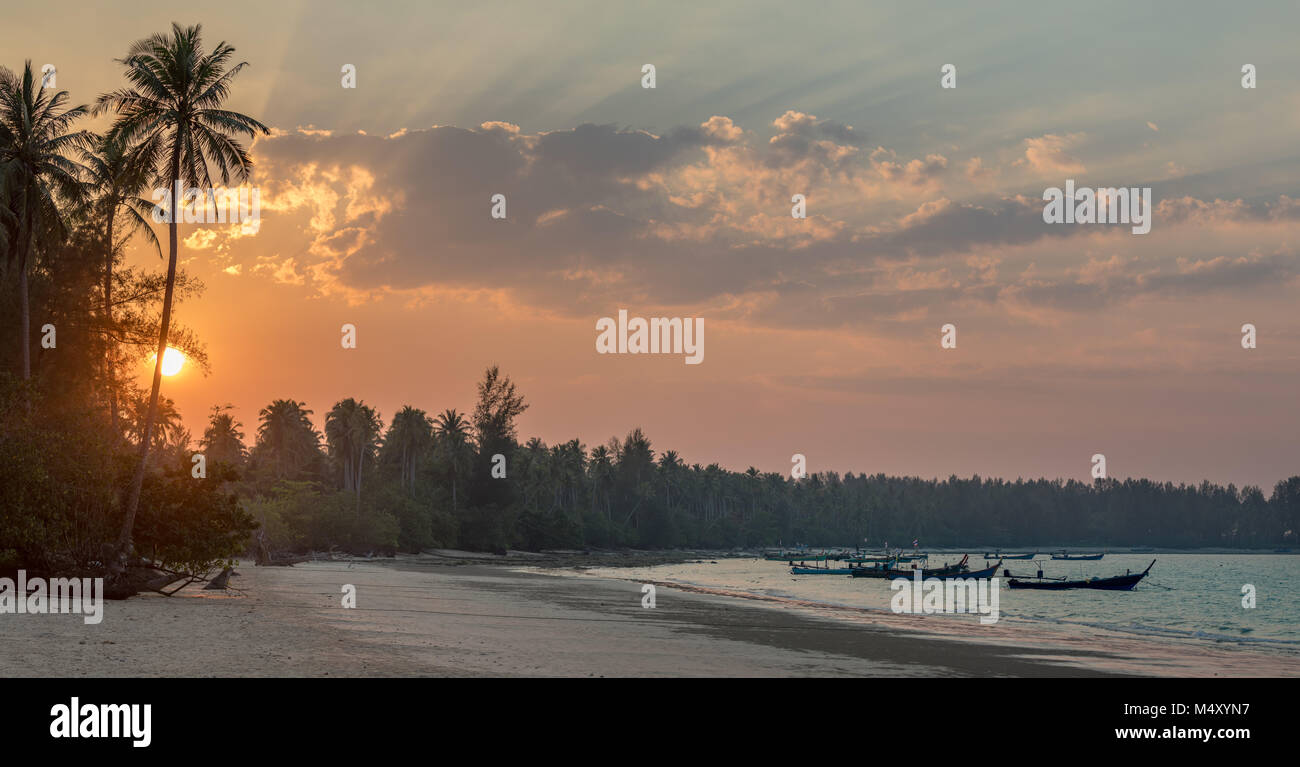 Classic Thailand sunset view with long tail boats, white sand beach, palms, ocean, sun and sky, huge 75MP panorama Stock Photo