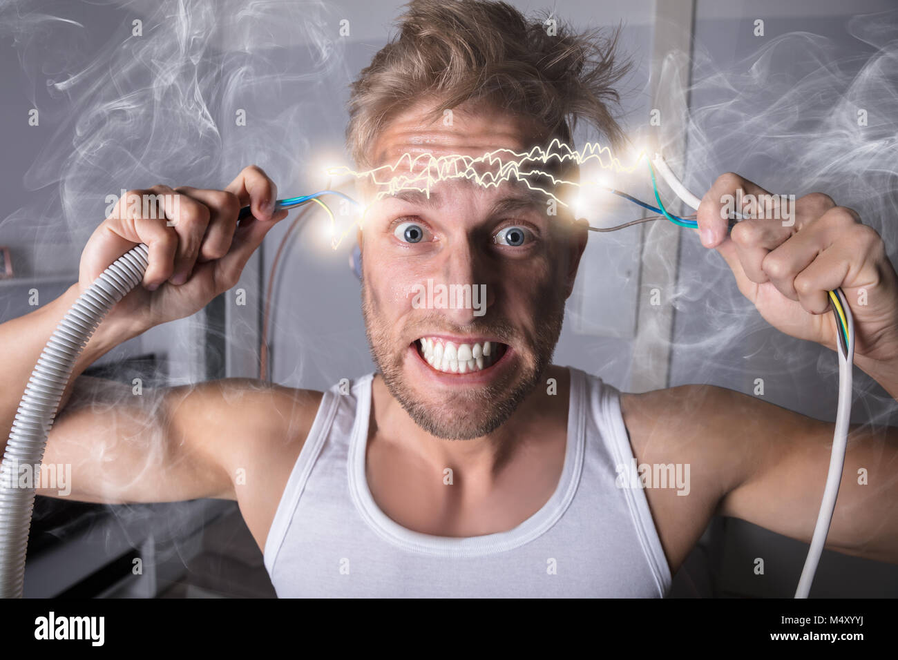 Portrait Of A Man Holding Bared Wires And Screaming Of Pain Stock Photo