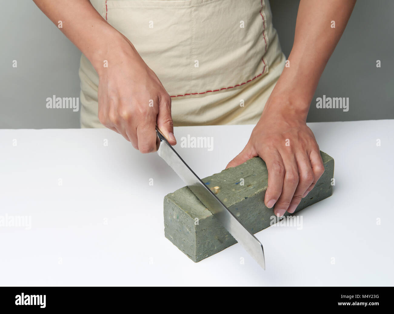 A lady cutting a loaf of soap with a piano wire soap cutter Stock Photo -  Alamy