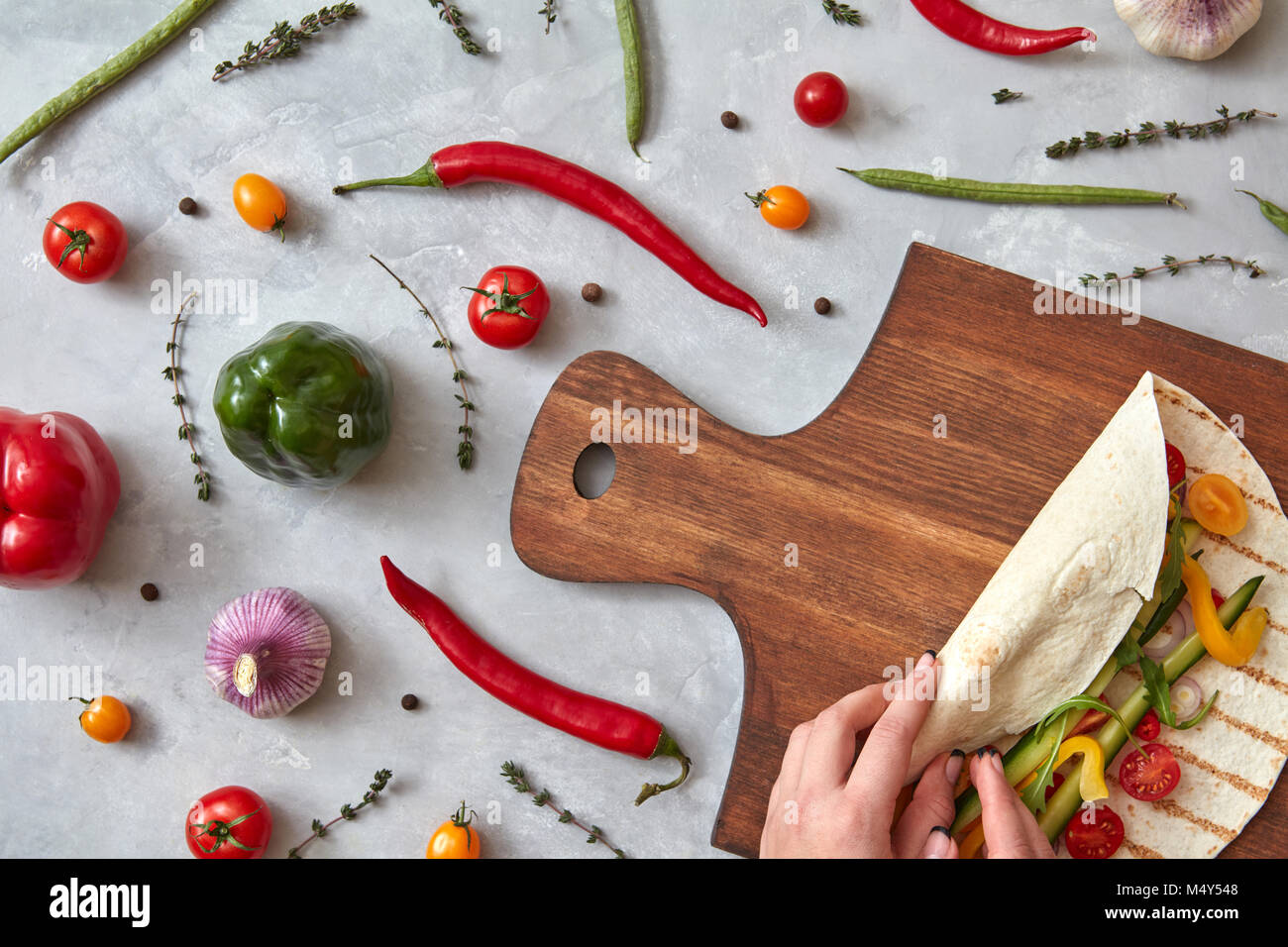 woman makes a burrito with vegetables Stock Photo