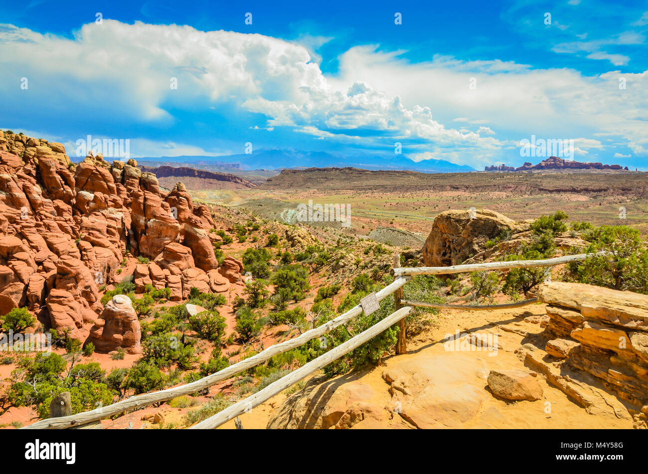 Wood log fence marks boundary of scenic overlook above fiery furnace rock formation at Arches National Park. Stock Photo