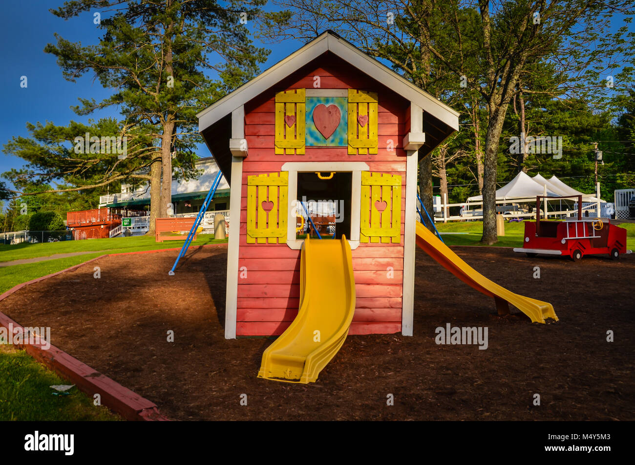 Colorful Playhouse with yellow slides on playground Stock Photo Alamy