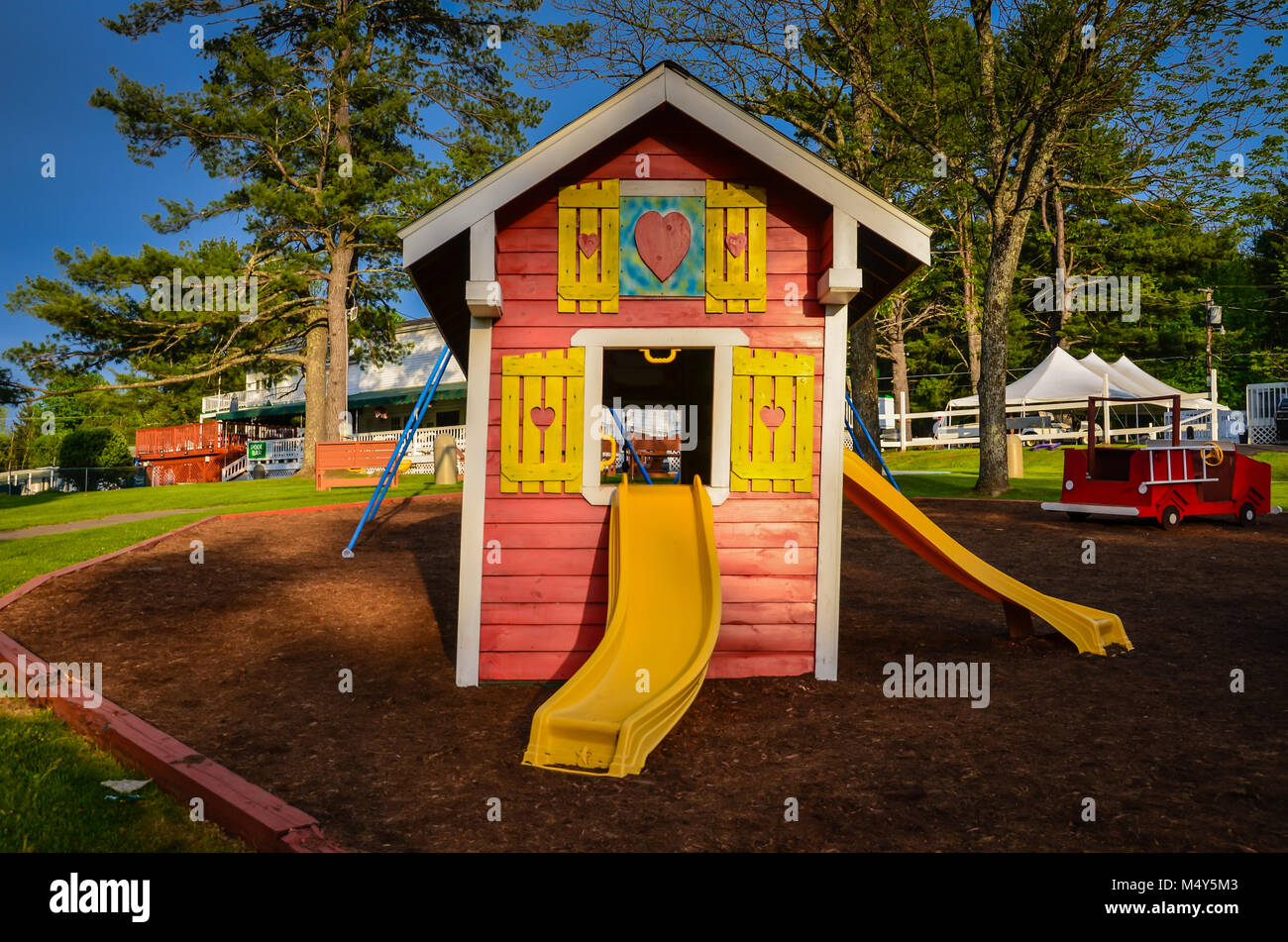 Colorful Playhouse with yellow slides on playground. Stock Photo