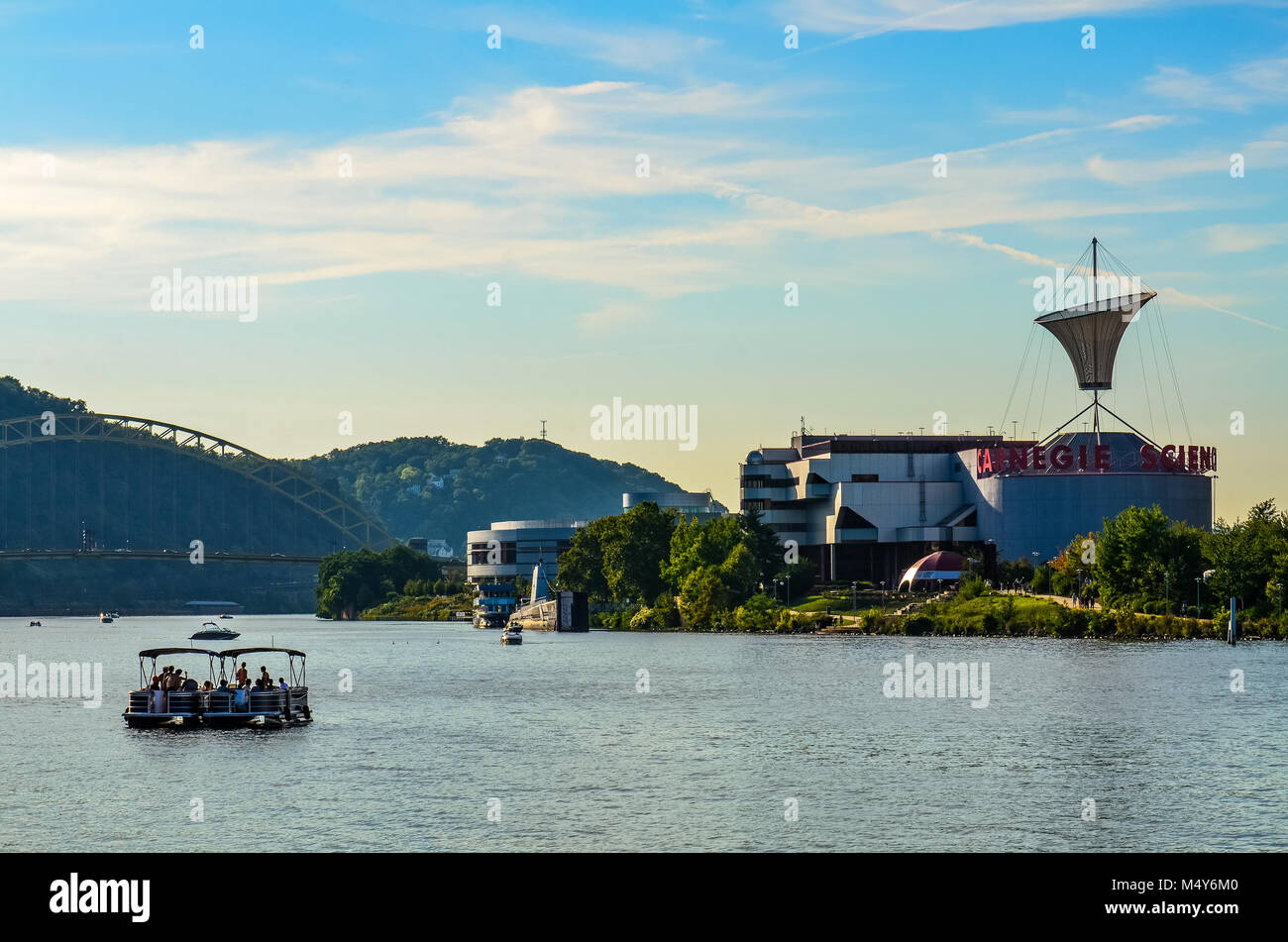 View of Ohio River with bridge and the Carnegie Science Center museum at center, with a party boat in the foreground, as seen from Point State Park. Stock Photo