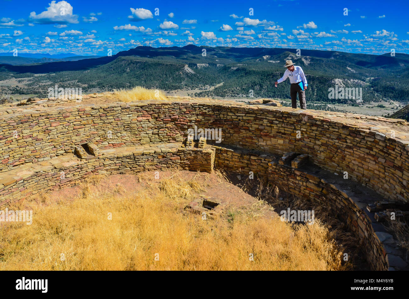 Tour guide explains history of  Pueblo people at kiva in Chimney Rock National Monument. Stock Photo