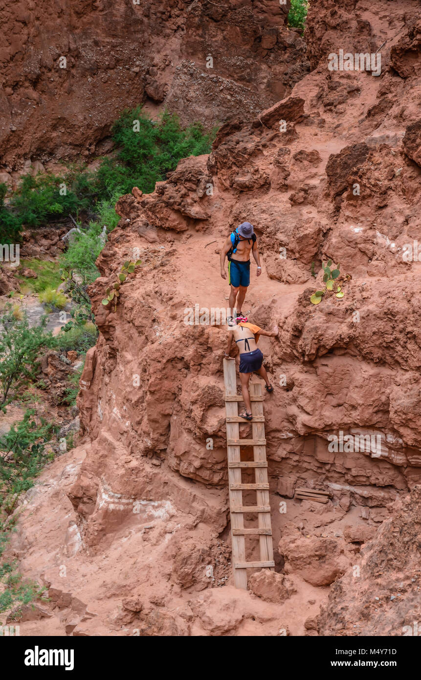 Couple climbs wooden ladder to Beaver Falls, one of the waterfalls sprouting from Havasu Creek