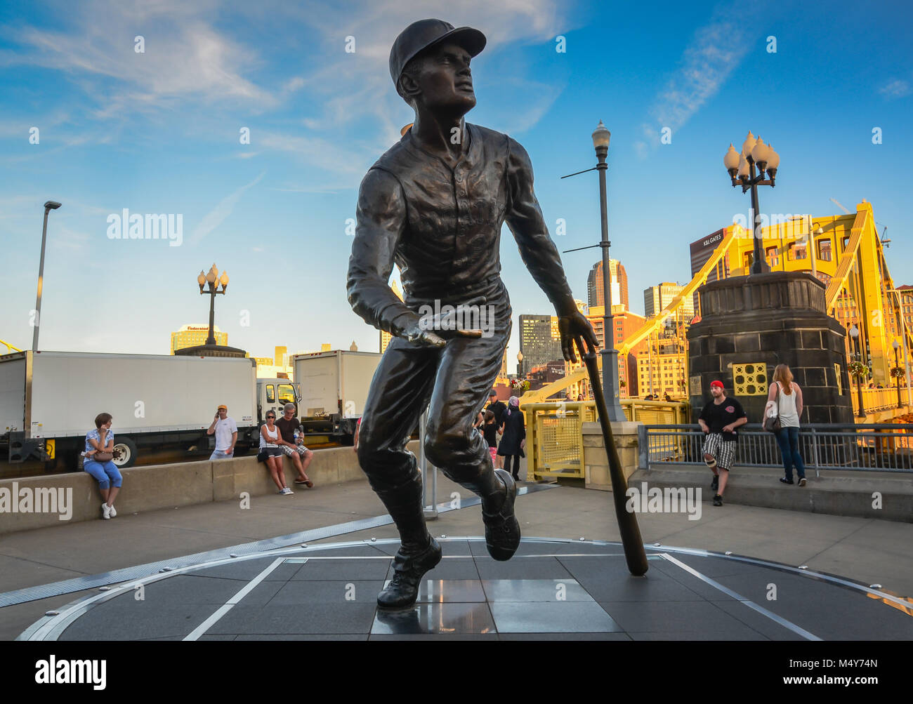 Statue of famous baseball player Roberto Clemente at Pittsburgh Pirates' PNC Park arena in front of yellow bridge named after him. Stock Photo
