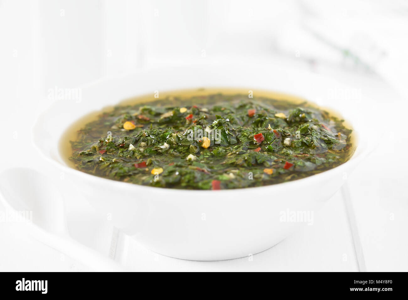 Raw homemade Argentinian green Chimichurri or Chimmichurri salsa or sauce made of parsley, garlic, oregano, hot pepper, olive oil, vinegar Stock Photo
