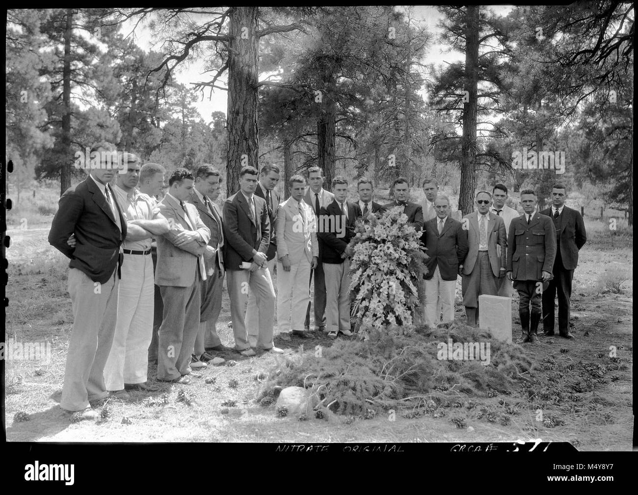 MEMBERS OF THE YALE, HARVARD & PRINCETON FOOTBALL TEAMS (ENROUTE TO THE LOS ANGELES OLYMPIC GAMES) PAY TRIBUTE TO ROBERT BINGHAM, FORMER YALE FOOTBALL PLAYER, & GRCA FOREST RESERVE RANGER. (1919) GRCA CEMETERY. JULY 1932 .  First used before the establishment of the national park but not formally dedicated until 1928, the cemetery serves as a resting place for many early Grand Canyon families and pioneers. The cemetery—part of the Grand Canyon Village National Historic District—has more than 390 individual graves, several of which date back to before the establishment of the park and the dedic Stock Photo