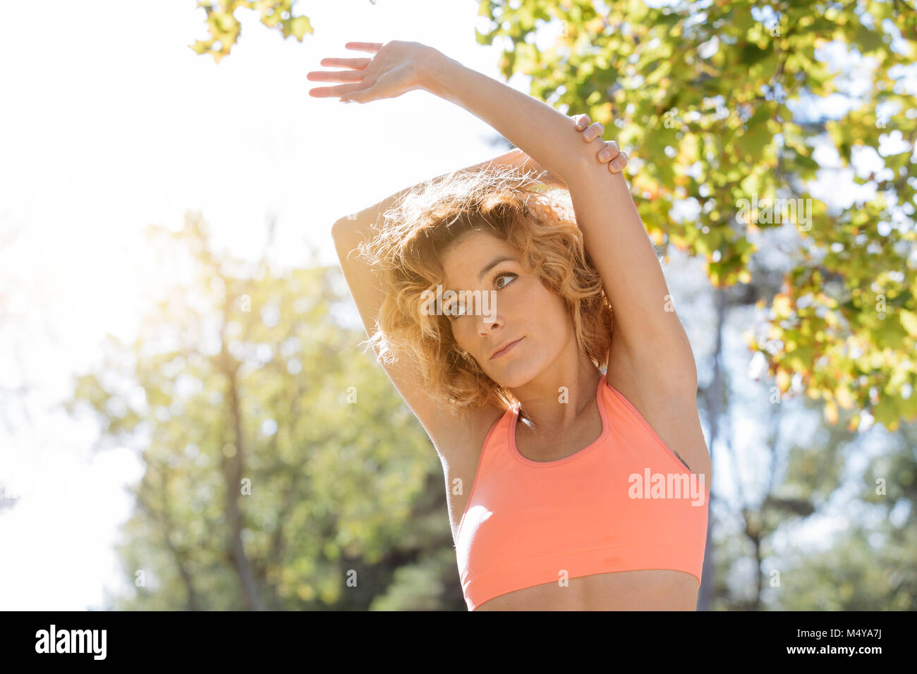 young fitness woman runner stretching arm before run Stock Photo