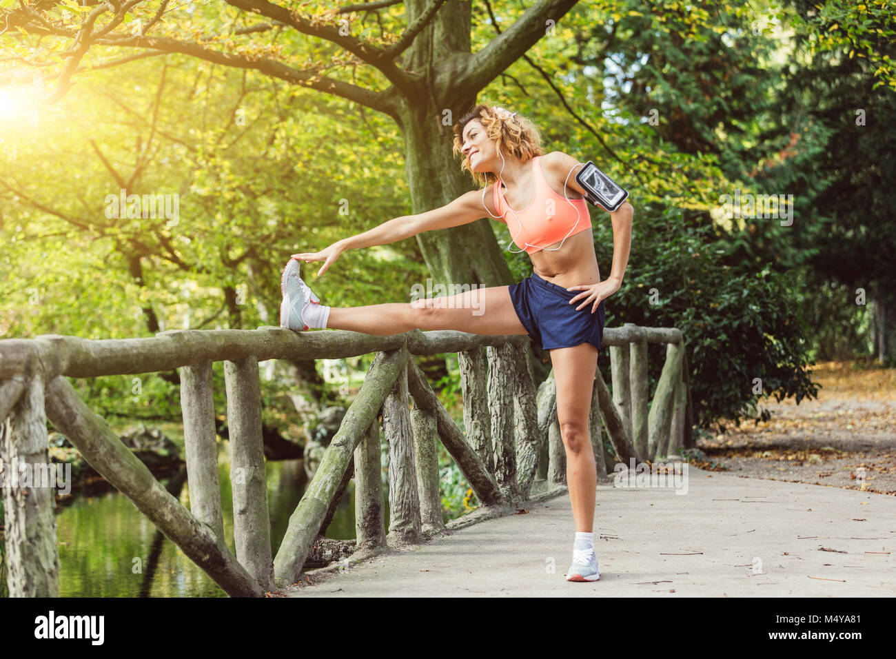 young fitness woman runner stretching legs before run Stock Photo