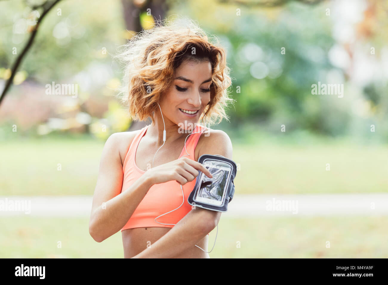 Runner athlete listening to music in headphones from smart phone mp3 player Stock Photo