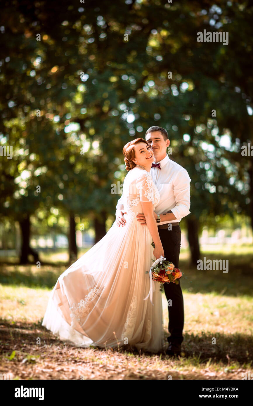 The bride and groom in the background of park trees Stock Photo - Alamy