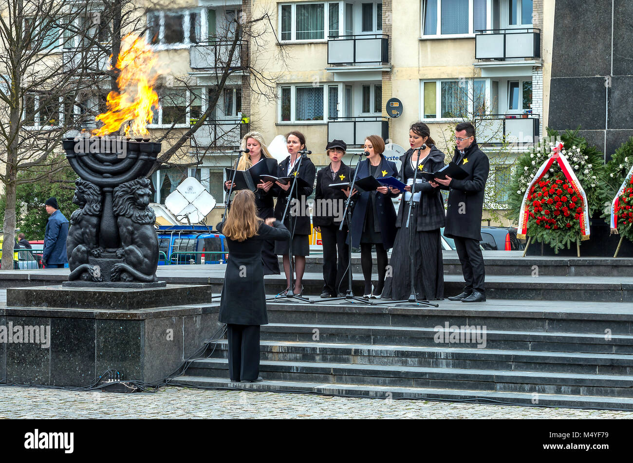 Poland, Warsaw: Choir singers perform during a ceremony at the Warsaw Ghetto Heroes Monument. Stock Photo