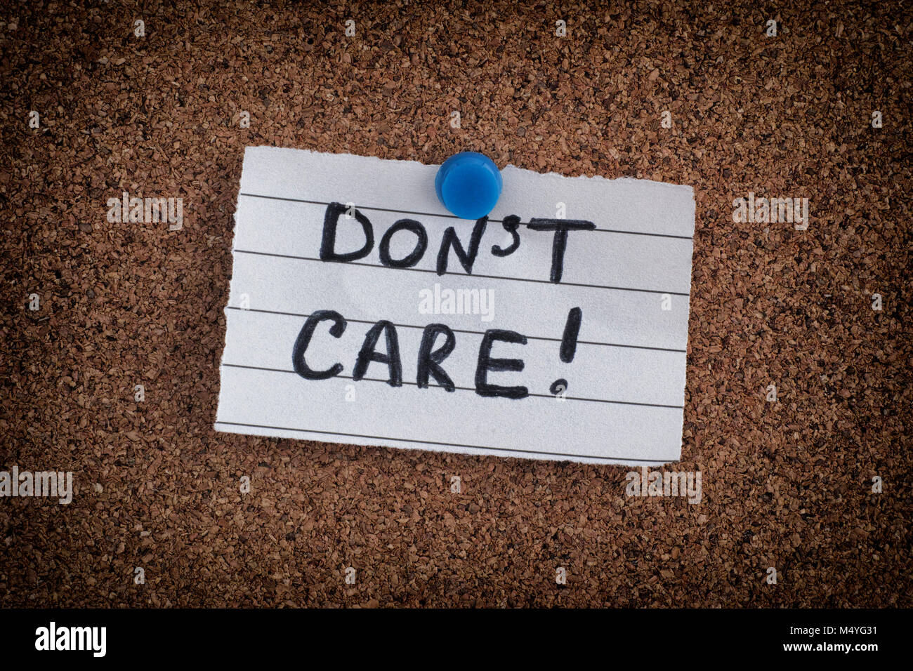 Paper note with the phrase Don't Care on bulletin board. Close up. Stock Photo