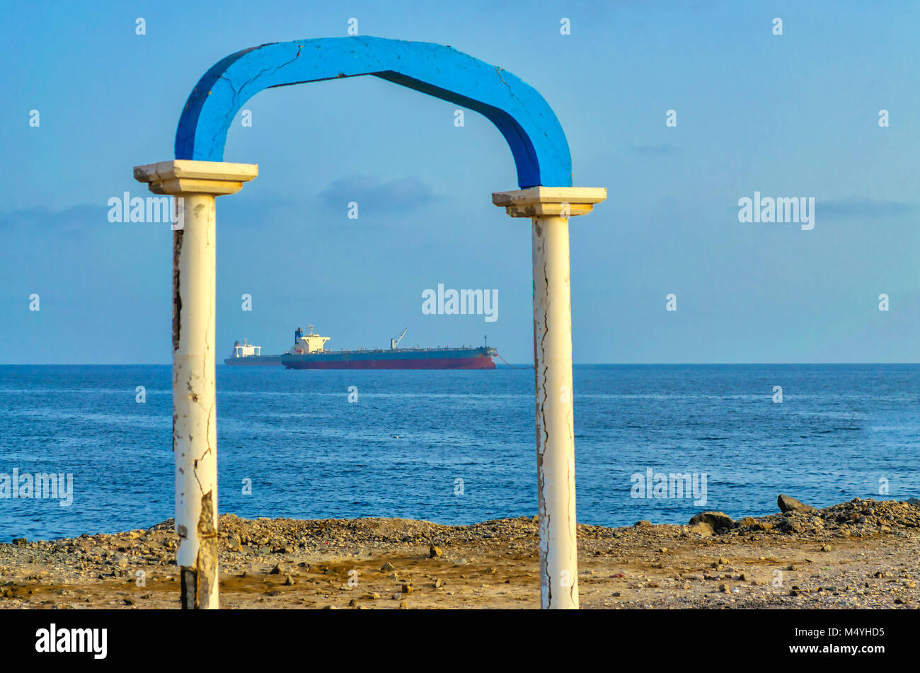 Two ships framed by an old, ruined arch on the beach. Stock Photo