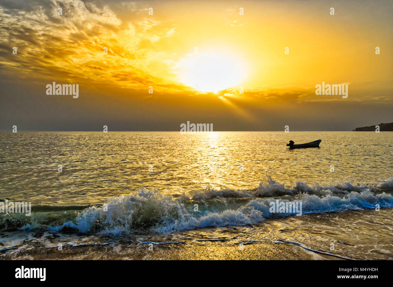 Lonely boat during sunrise and an orange sky Stock Photo