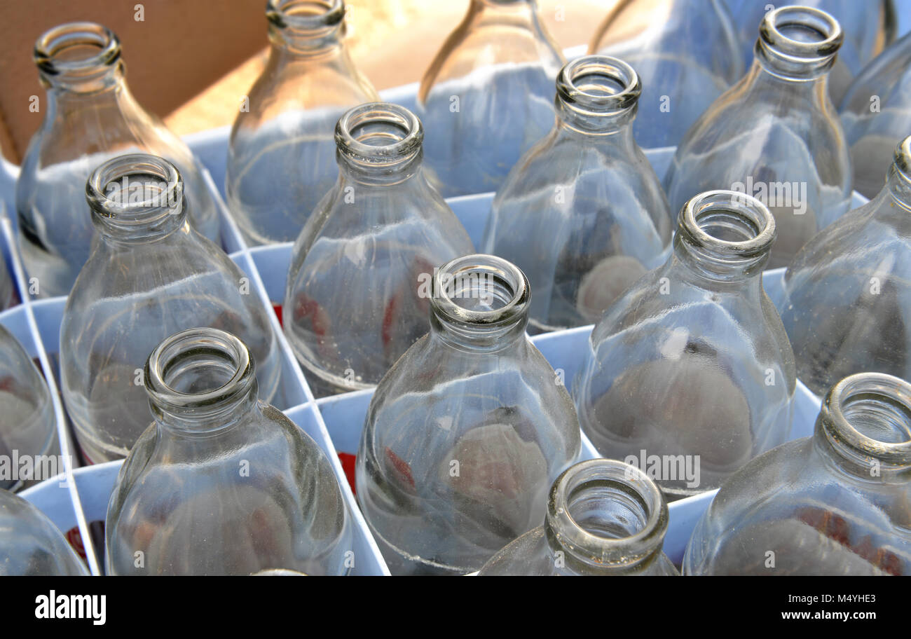 Used soda water glass bottle in the hole wait for recycle photo in outdoor sun lighting. Stock Photo