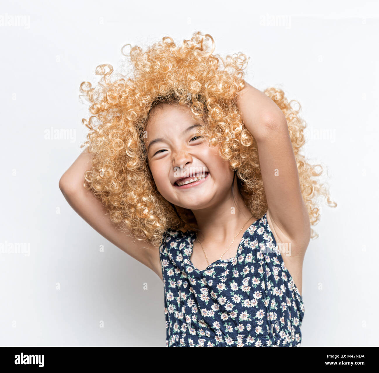 Wearing a blonde wig and funny facial expression Asian girl Stock Photo