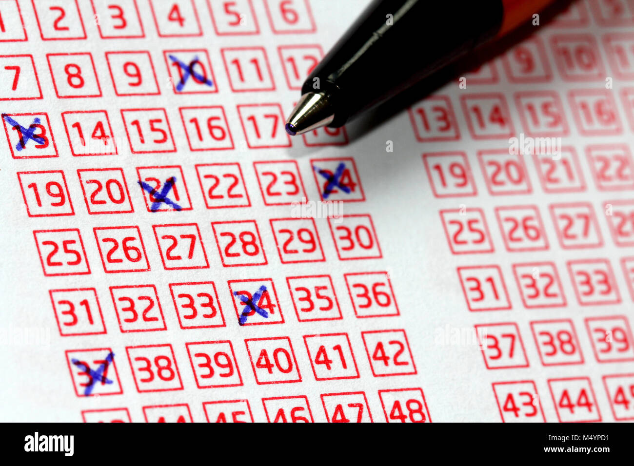 Pen and lucky numbers marked on a lottery coupon, shallow depth of field. Stock Photo