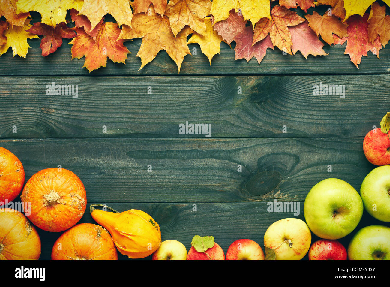 Autumn leaves, apples and pumpkins over wooden background Stock Photo ...