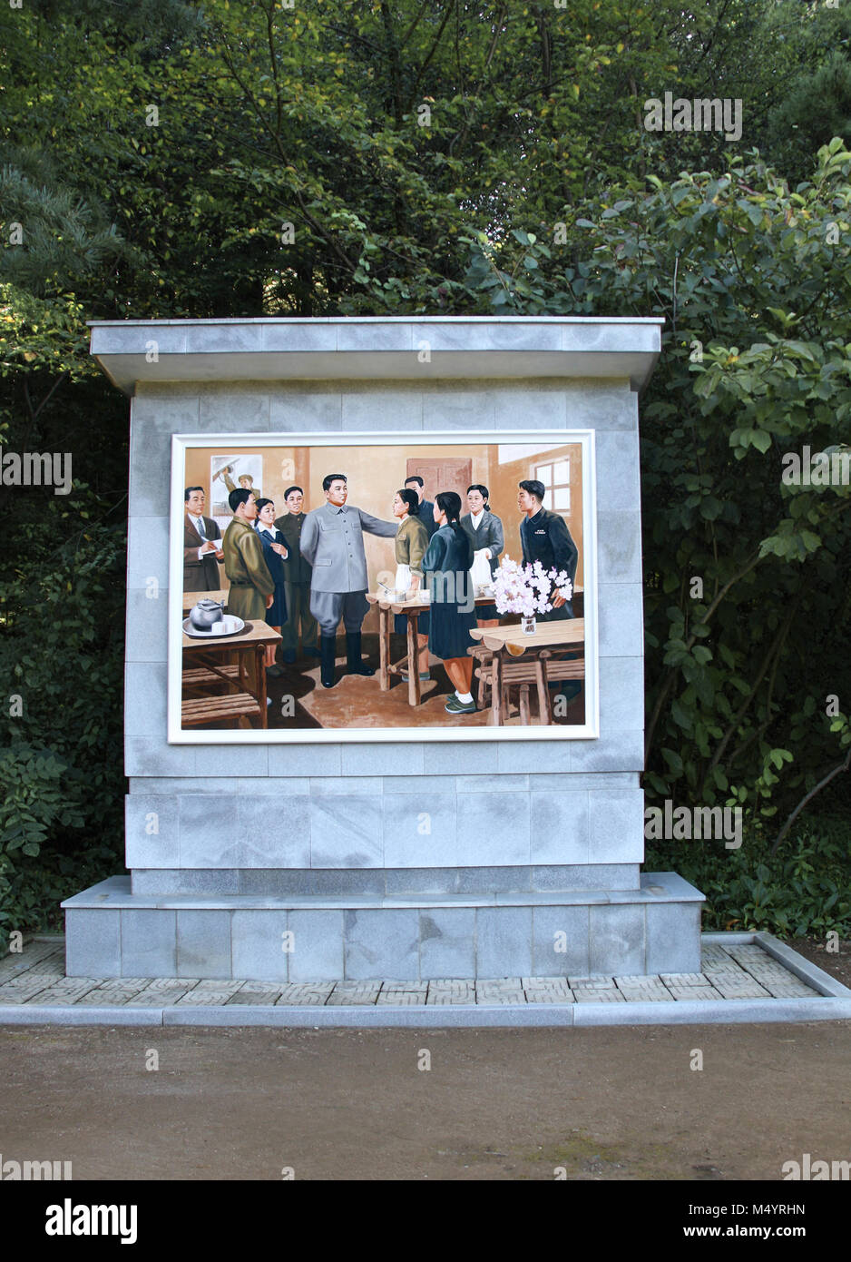 NORTH KOREA, PYHENSON - SEPTEMBER 19, 2017: Stele with picture 'Great leader comrade Kim Il Sung speaks with students', revolutionary historical site  Stock Photo