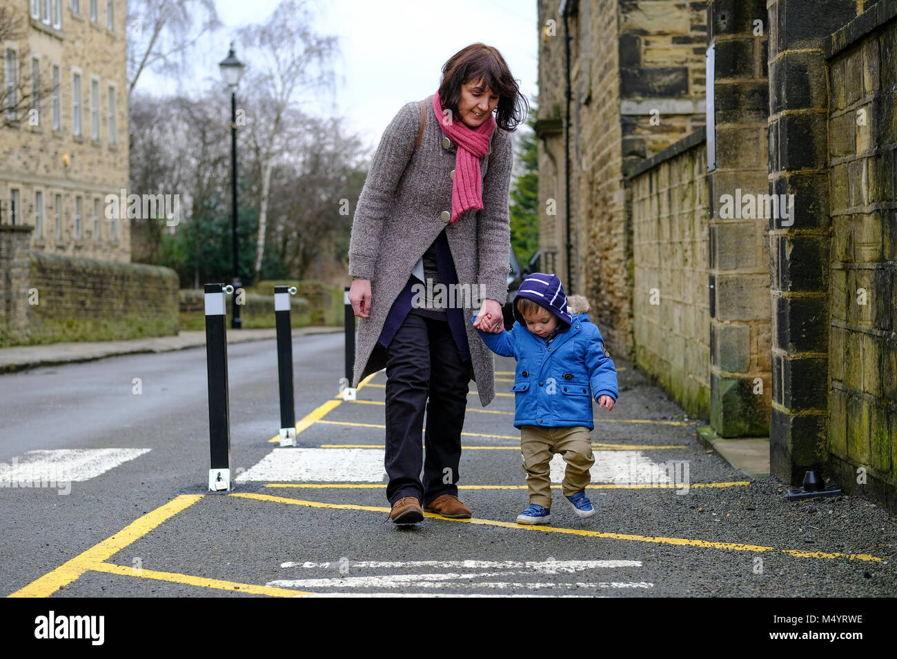Toddler holding hands with grandparent and walking outside Stock Photo
