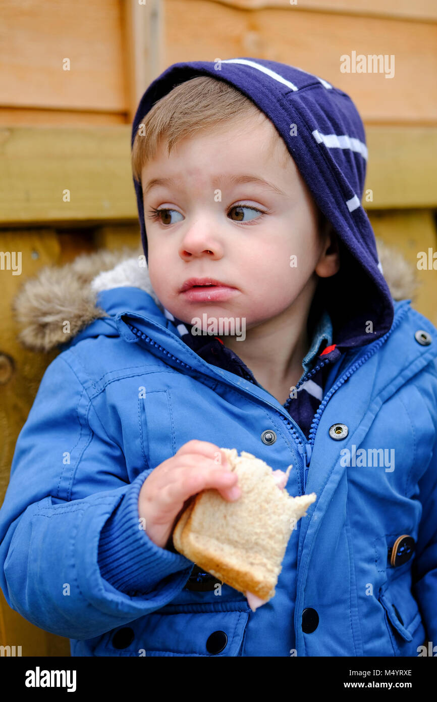 Toddler outside eating a sandwich Stock Photo