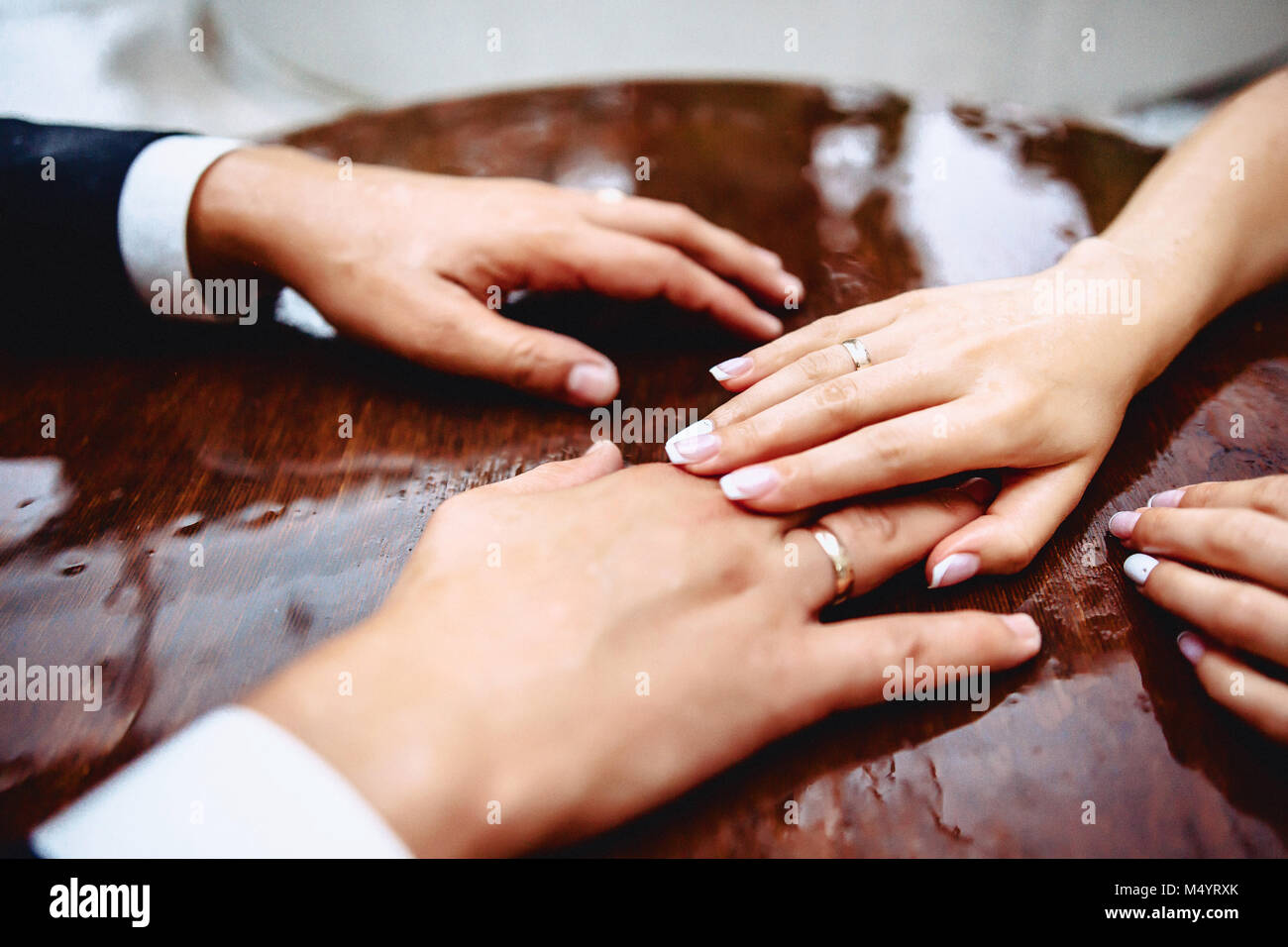 hands of brides on a table with drops of water during the rain Stock Photo