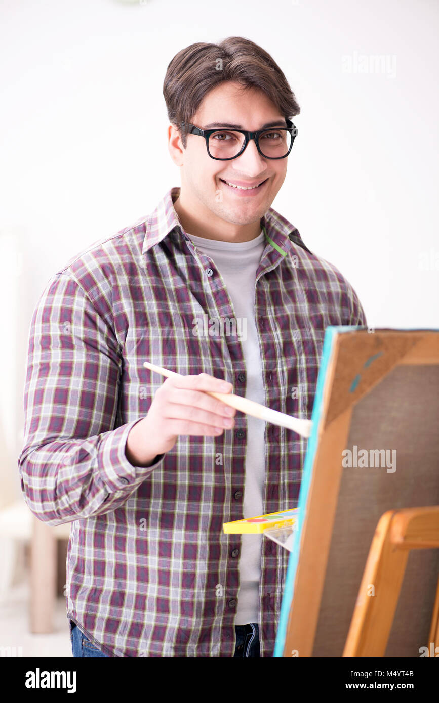 Young male artist drawing pictures in bright studio Stock Photo - Alamy