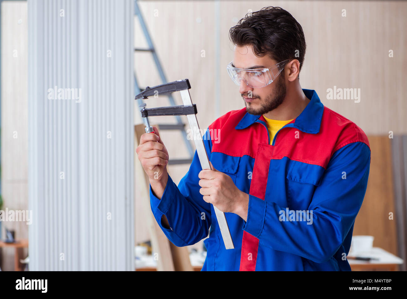 Young repairman carpenter working with clamps Stock Photo