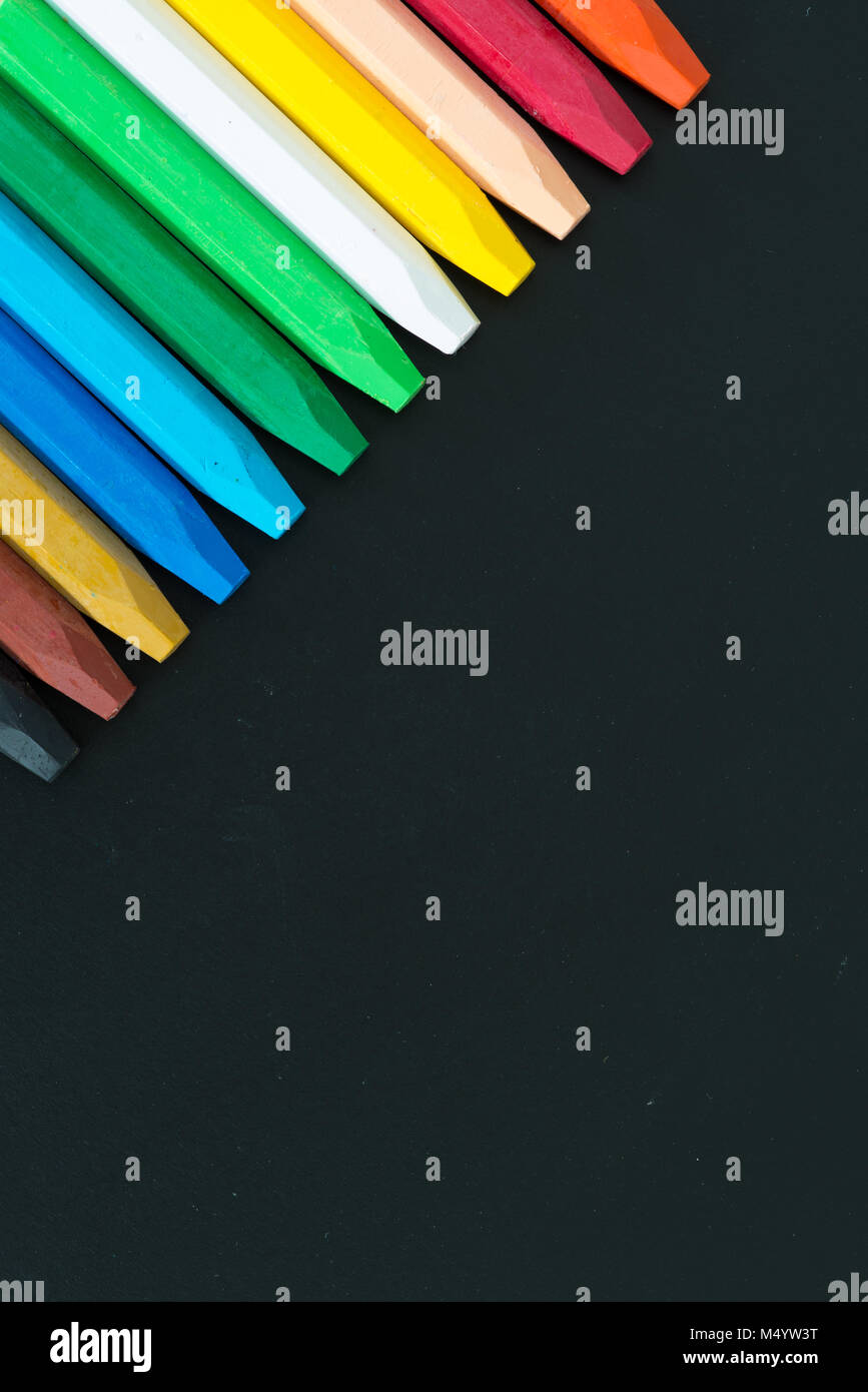 Row of multi colored wax crayons on the black board Stock Photo - Alamy