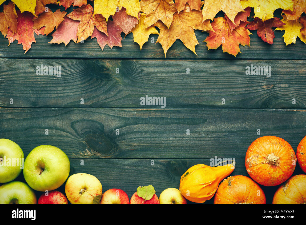 Autumn leaves, apples and pumpkins over wooden background Stock Photo ...