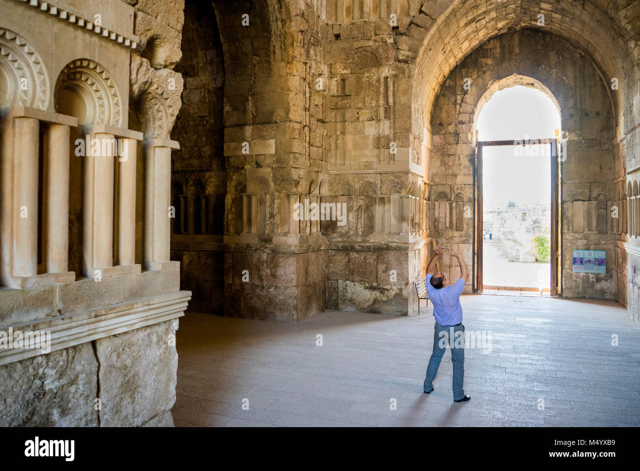 Man looking up taking photo with his cell phone in Umayyad Palace, Amman Citadel, Amman, Jordan Stock Photo