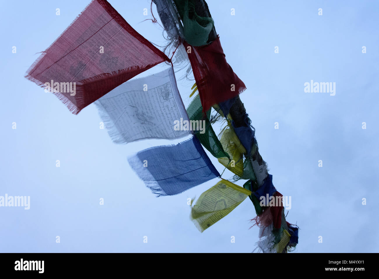 Prayers inscribed on Tibetan Prayer Flags whirling in the wind. Stock Photo