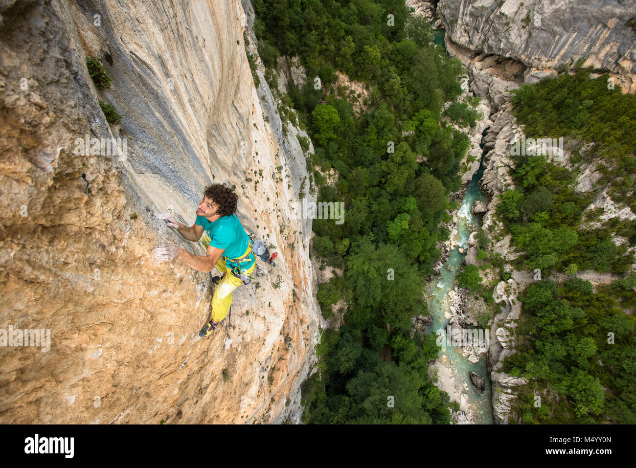 View from above of male rock climber climbing rock face, Verdon