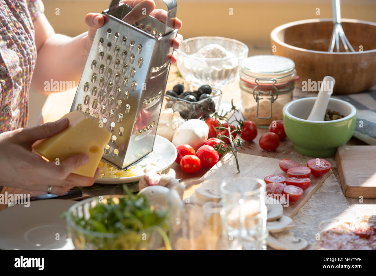 https://c8.alamy.com/comp/M4YYWR/woman-cooking-pizza-at-home-unrecognizable-woman-grating-cheese-M4YYWR.jpg