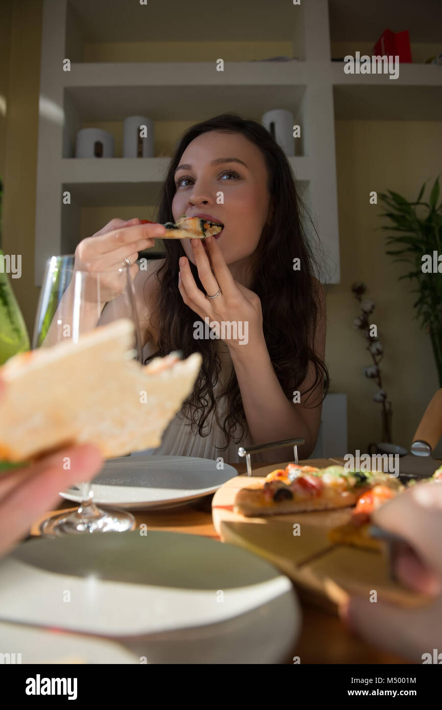 Romantic couple dating at home. Drinking red wine, eating fresh homemade pizza. Photo from the first person Stock Photo