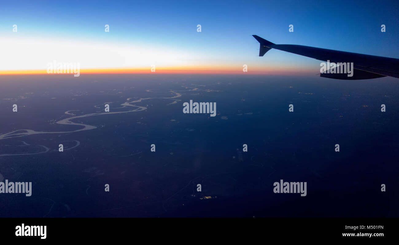 flying at night over cities below Stock Photo