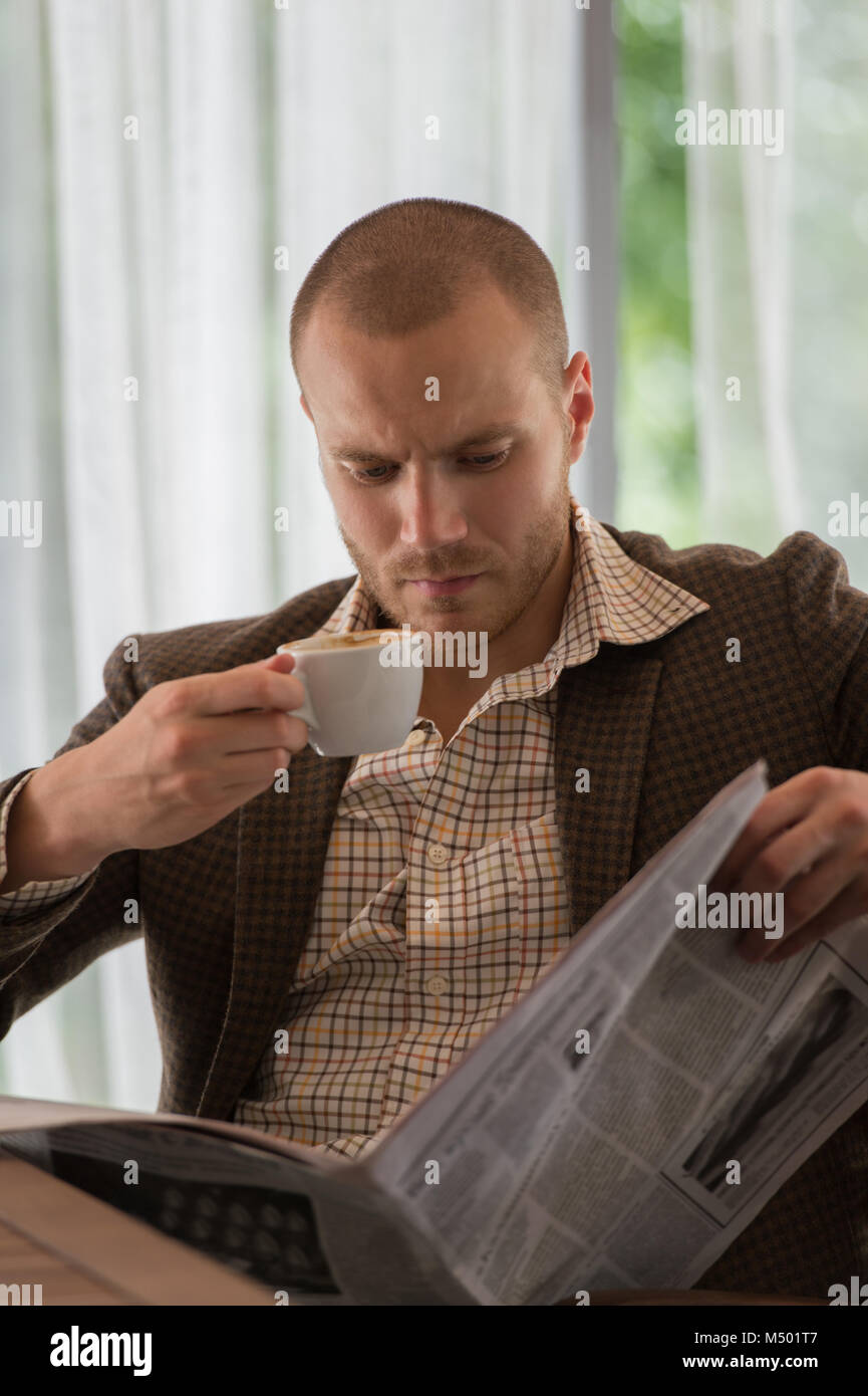 Pensive businessman reading a newspaper in cafe Stock Photo - Alamy